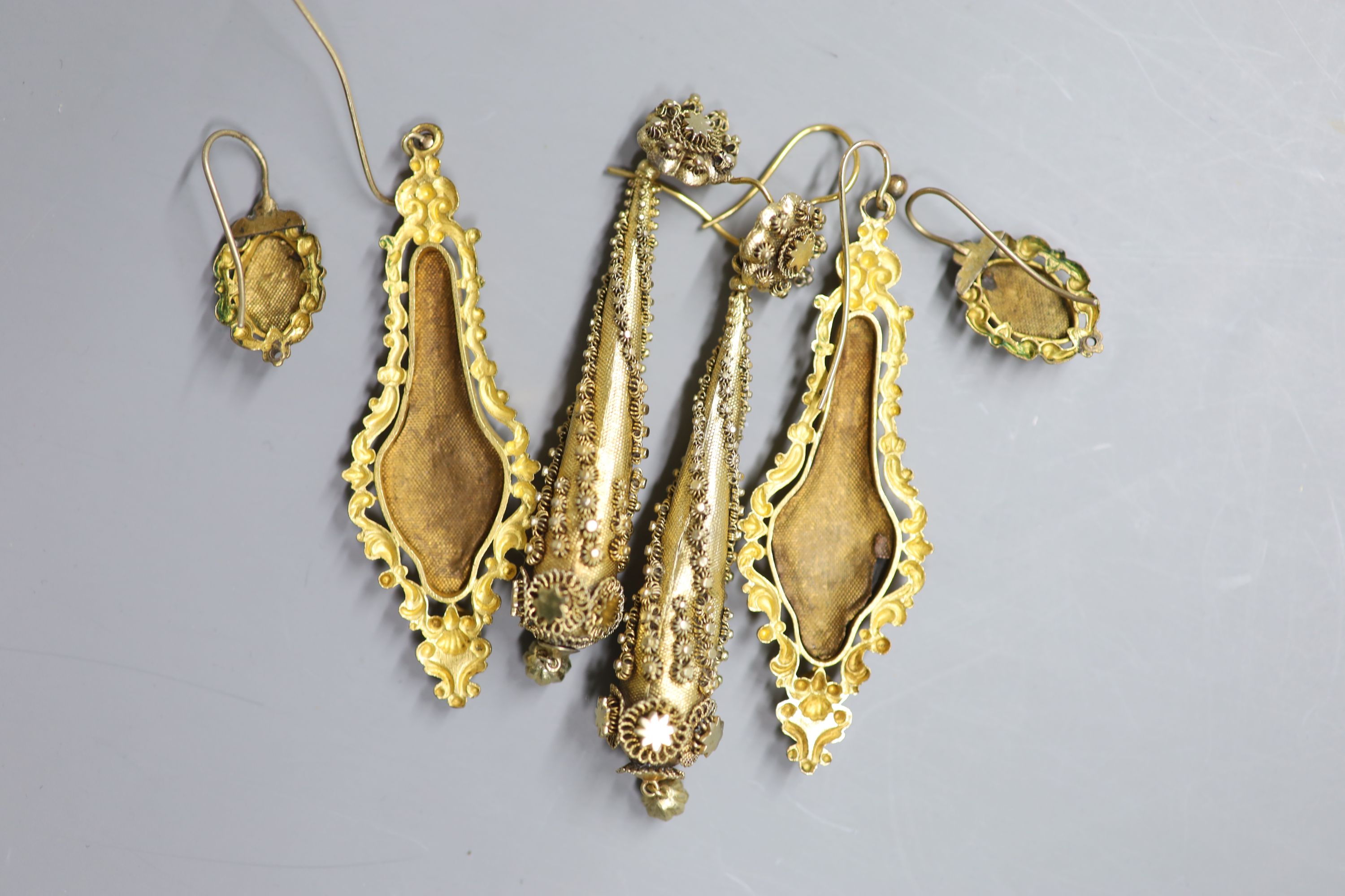 A pair of ornate Victorian gilt metal teardrop shaped earrings, 86mm and two later pairs.